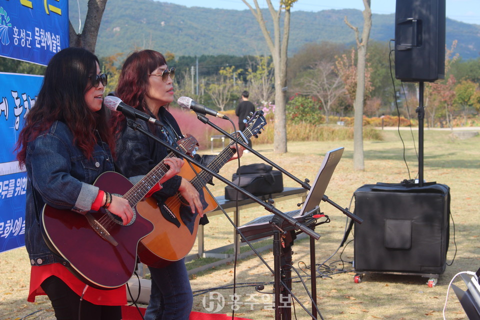 지난 18일 고암 이응노 생가 기념관 잔디광장에서 진행한 ‘차상위계층돕기 자선콘서트’의 시작으로 아름다운사람들의 모임의 김란경 회장과 이재경 씨가 통기타 연주를 하고 있다.