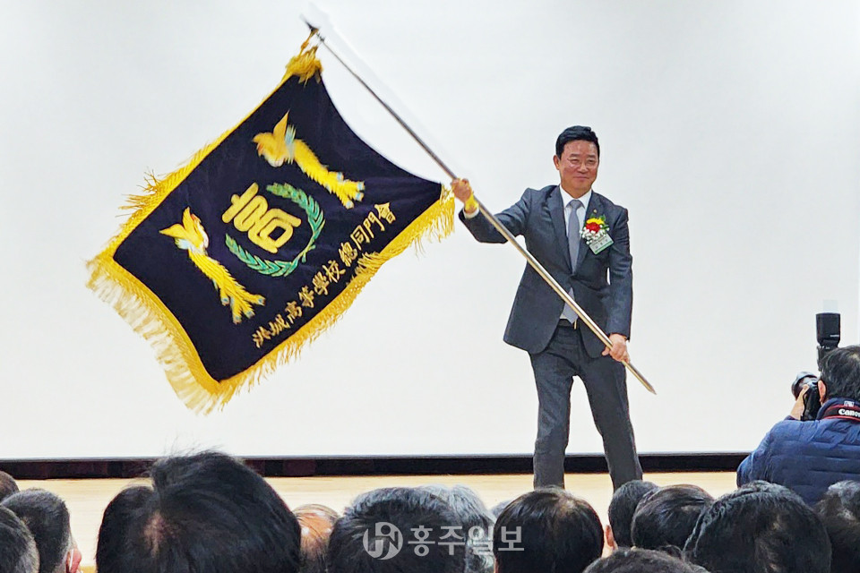김종호(30회) 취임회장이 총동문회기를 흔들어 보이고 있다.
