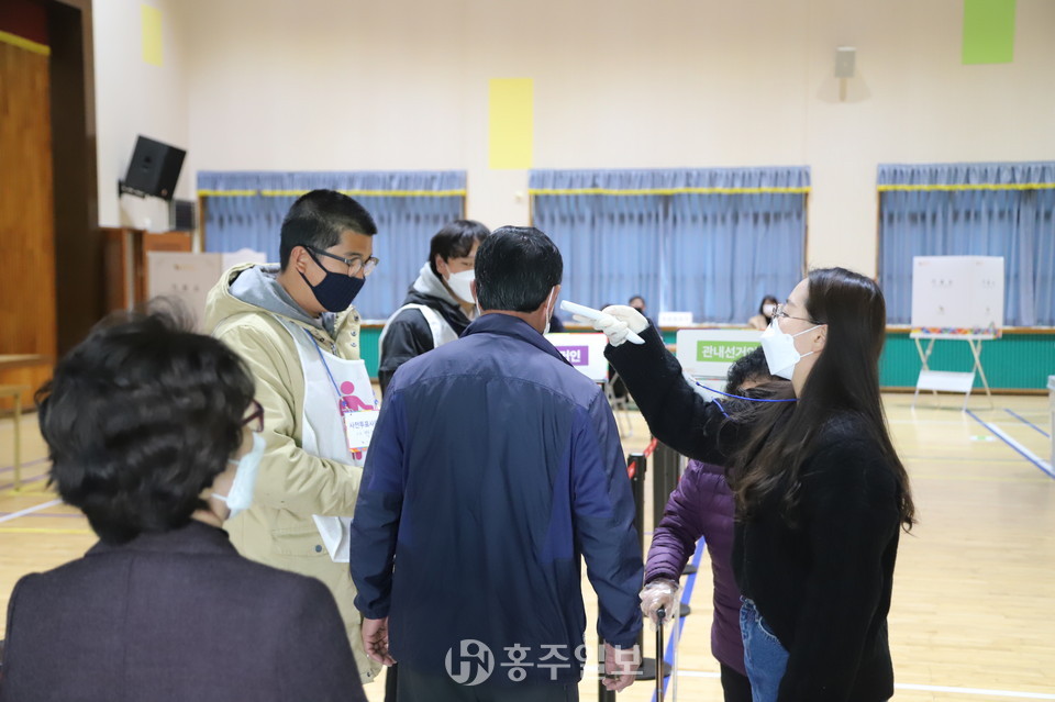 선관위 직원의 안내로 간단한 코로나19 감염예방을 위한 발열체크를 후 투표절차를 밟고 있는 유권자들. 지난 11일 홍성군 장곡면사전투표소에서 사전투표하고 있는 유권자들의 모습.