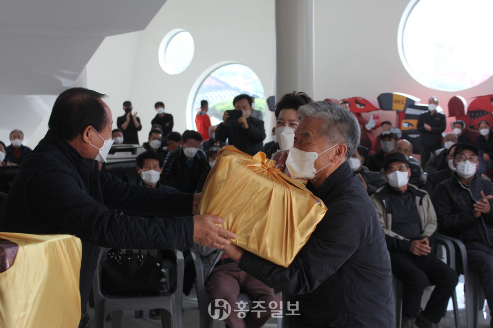 동기인 김재수 고문(17회)에게 선물을 전달 받고 있는 장사익 동문(17회).