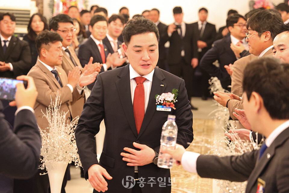 정동식 신임회장이 내빈들의 축하 박수갈채 속에 무대로 입장하기 위해 당당한 걸음을 걷고 있다.